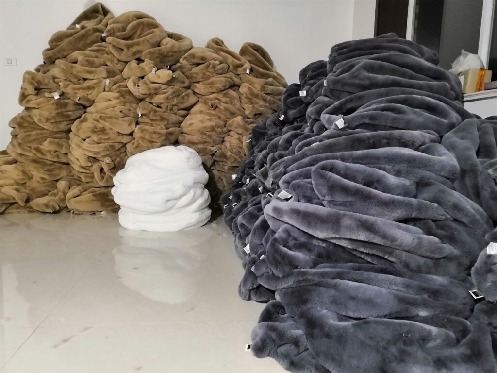 Grey, tan and white faux fur products stacked in batches