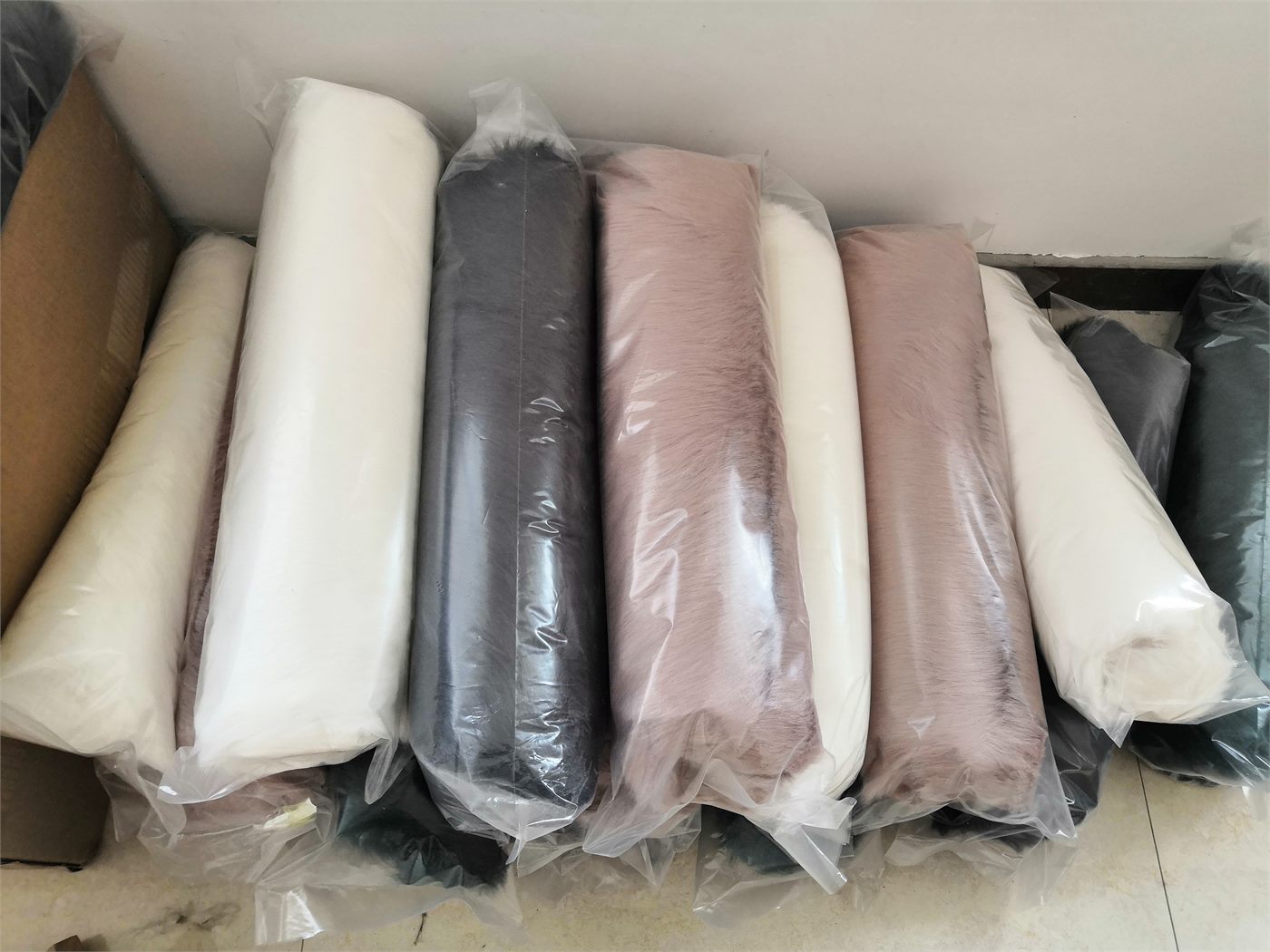 Rolled faux fur blankets packed in clear sleeves for export