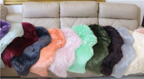 Faux fur rug color options displayed on sofa for wholesale home decor buyers